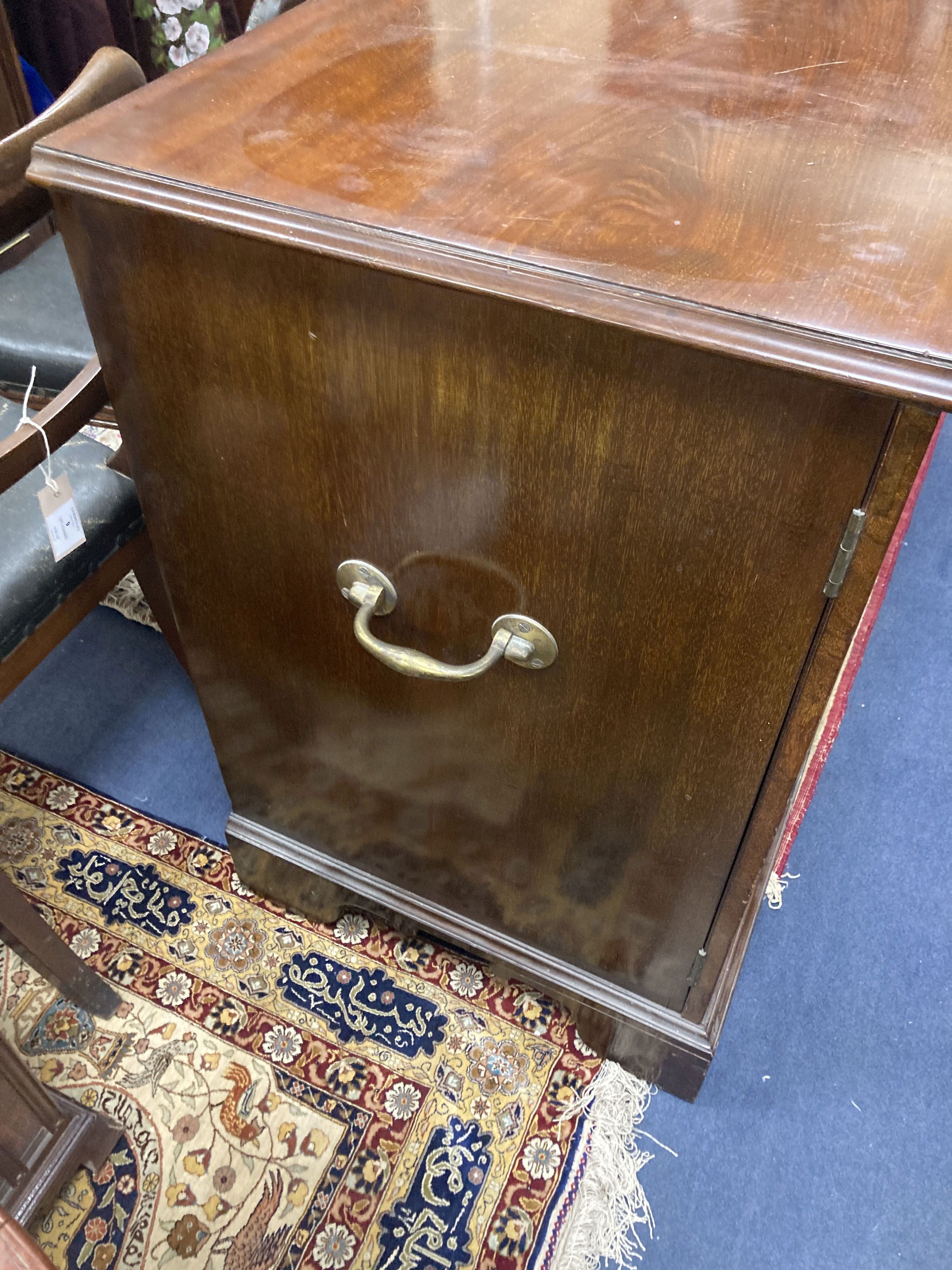 A late Victorian mahogany cupboard, fitted with a pair of fielded panelled doors, flanked by brass side carrying handles